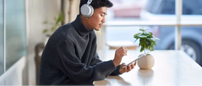 A man sitting at a table using a tablet.