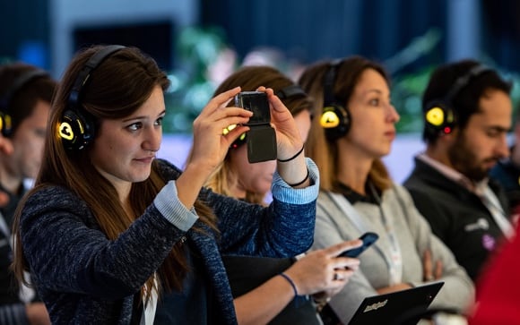Woman holding up her cell phone to capture a keynote moment.